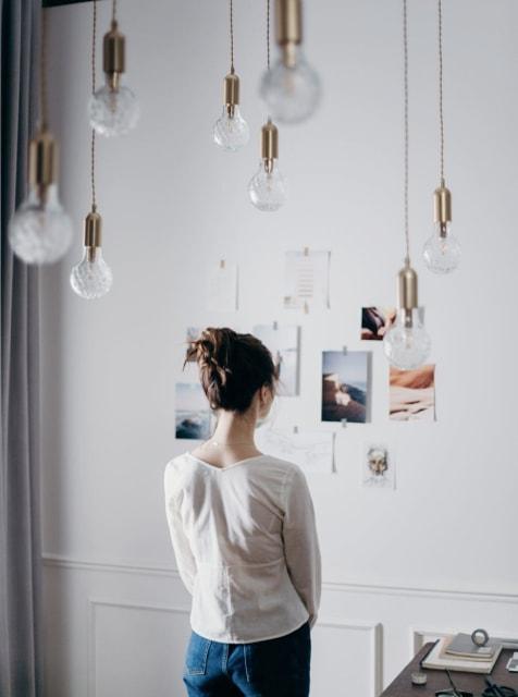 a lady looking at beautiful arts on the wall